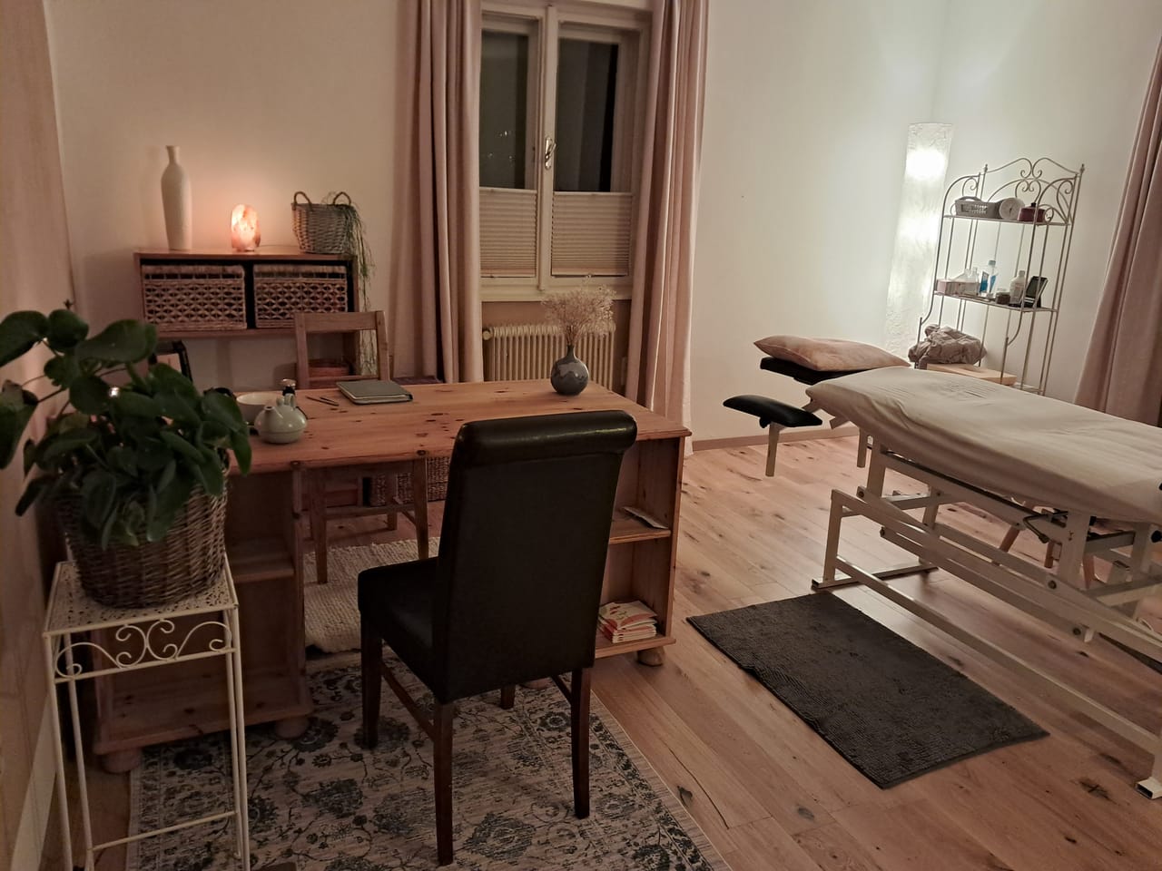 Behandlungsraum mit Massageliege und warmem Licht