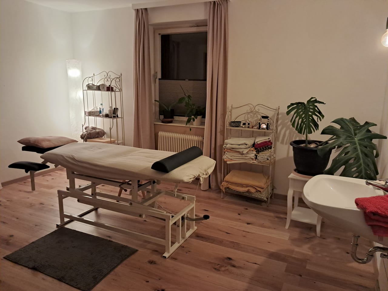 Behandlungsraum mit Massageliege, Handtüchern und Pflanzen